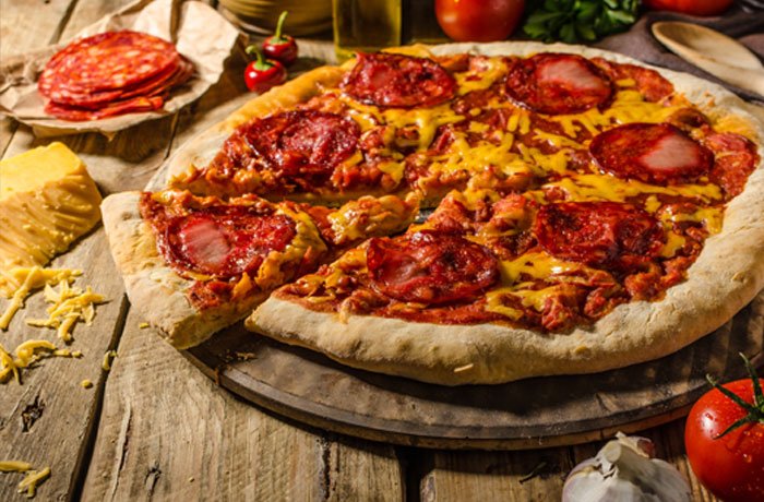 Jakie wino do pizzy z salami? Pizza z salami picante na stole w kuchni