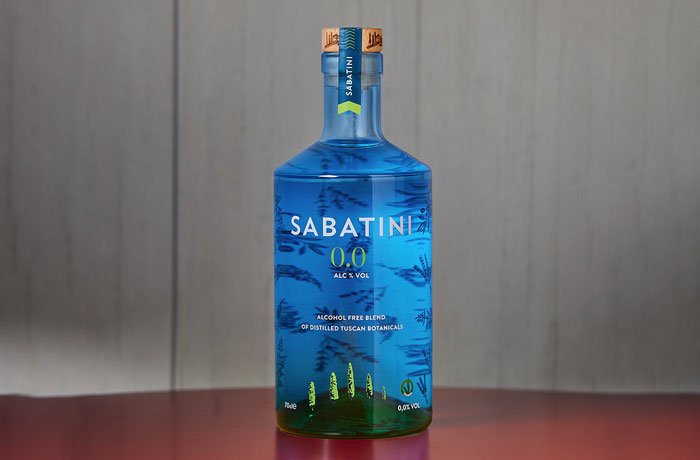 Gin bezalkoholowy w niebieskiej butelce na stoliku