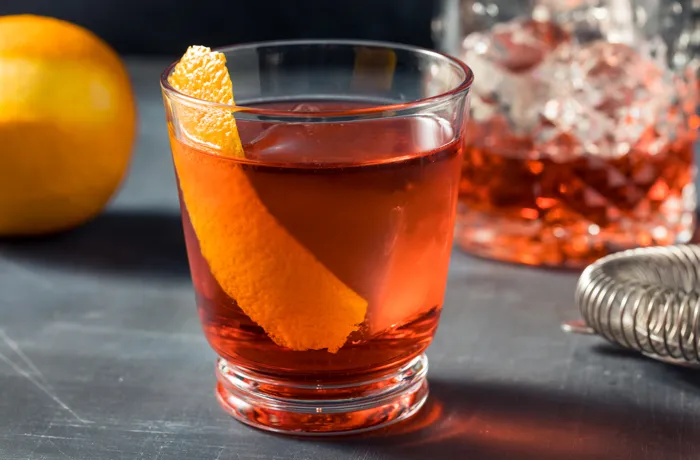 Dwa koktajle Negroni z cynamonem i pomarańczą na lodzie