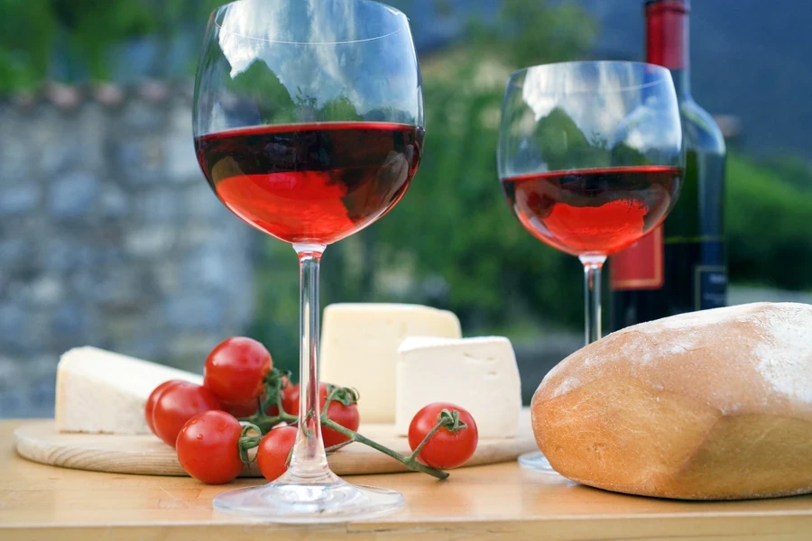 Włoskie aperitivo na tarasie - kieliszki wina i przekąski z przyjaciółmi o zachodzie słońca